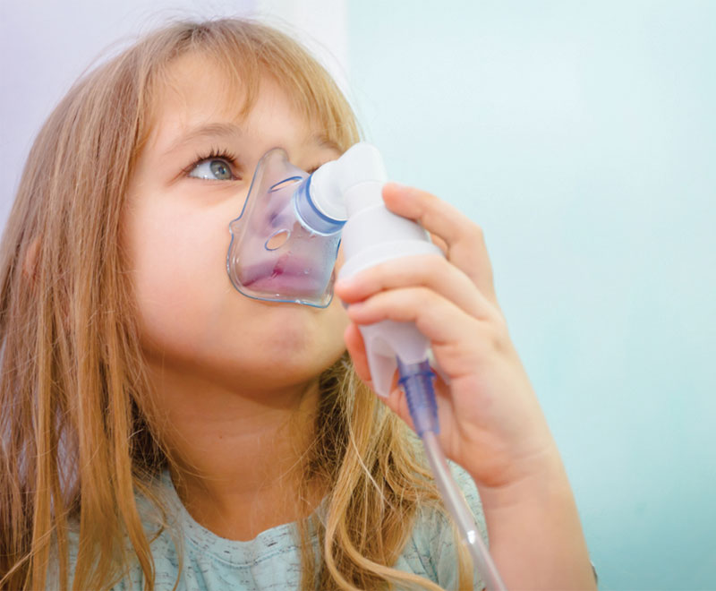 Photo of a little girl doing a breathing treatment.