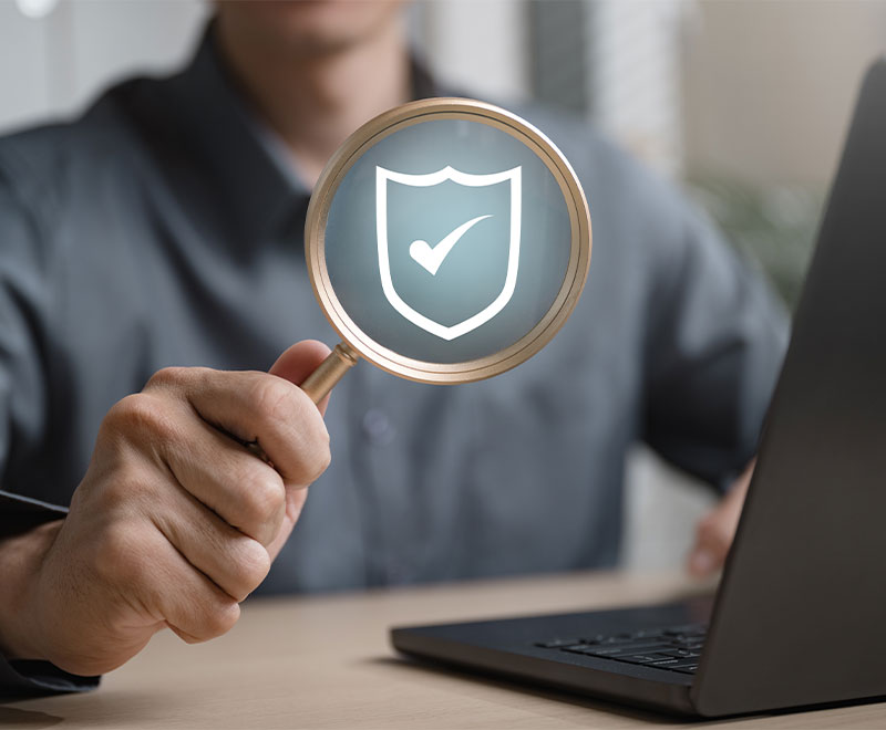 Photo of a man at a laptop with an illustration of a checkmark