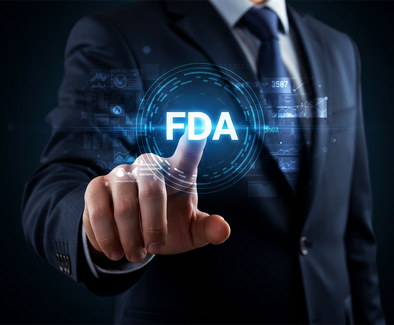Photo of a man wearing a suit touching a screen that says FDA