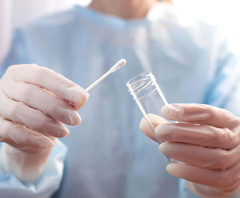 Healthcare worker holding saliva swab