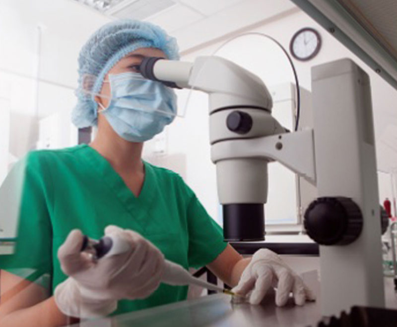 Photo of medical researcher looking through a microscope