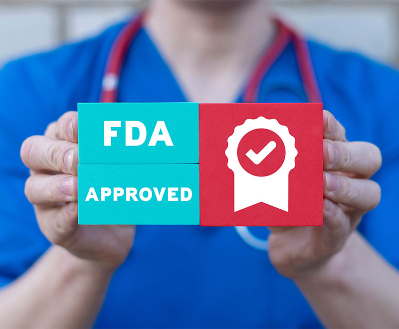 Photo of healthcare worker holding a sign that says "FDA Approved"