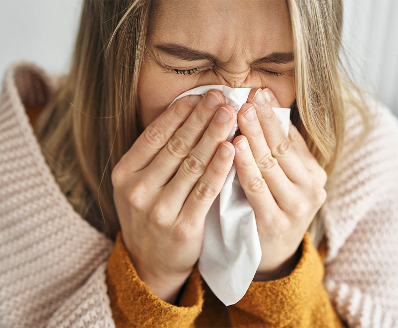 Photo of a woman sneezing