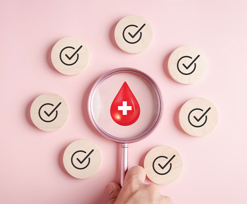 Image of a magnifying glass with a drop of blood inside, surrounded by wooden check marks