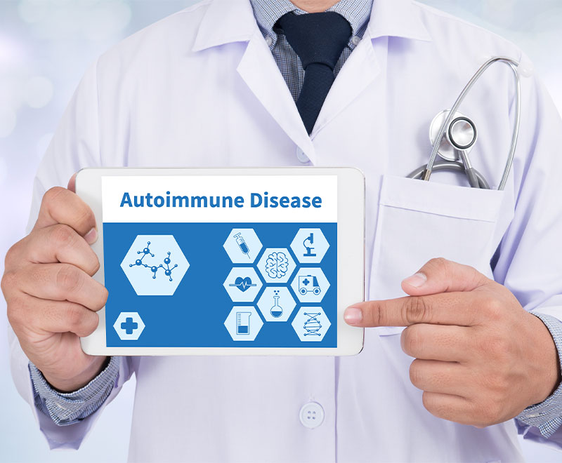 Photo of healthcare provider holding a sign that says autoimmune disease