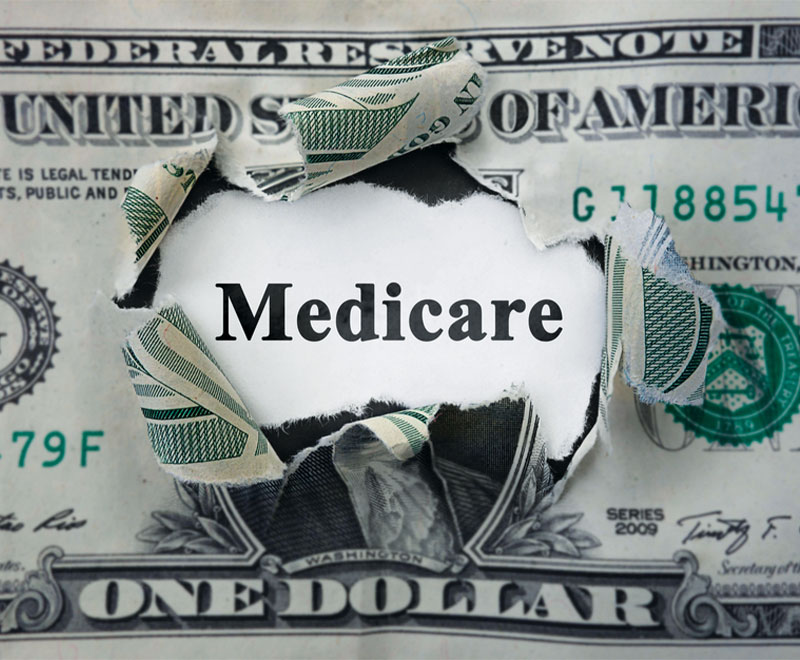 Image of a dollar bill torn in the middle, with the word "Medicare" in the middle