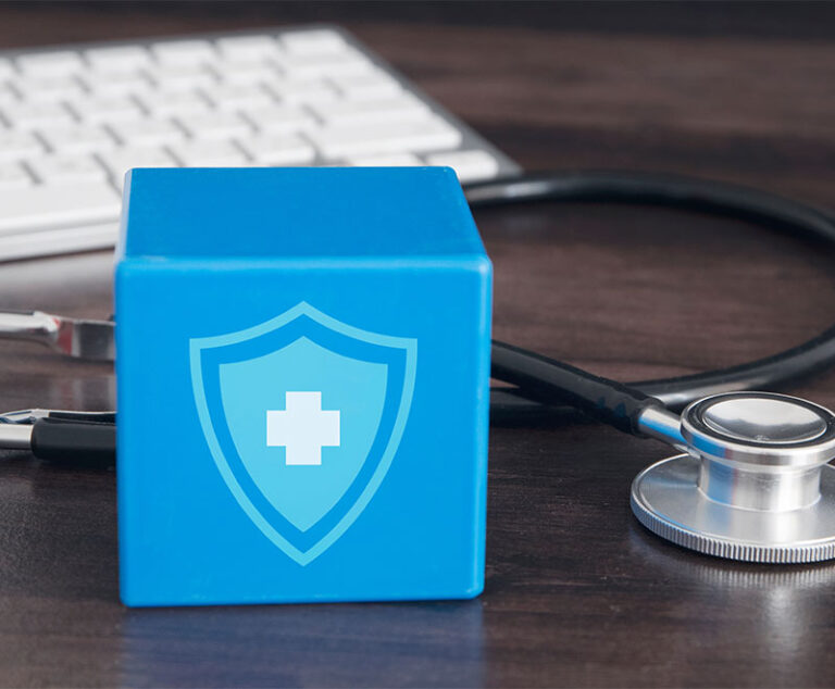 Image of a computer keyboard, stethoscope and blue box with a medical symbol