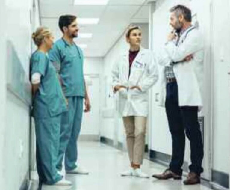Image of healthcare workers chatting in hospital hallway