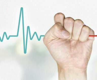 Hand holding an EKG heartbeat line