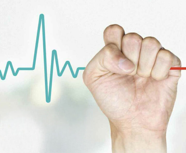 Hand holding an EKG heartbeat line