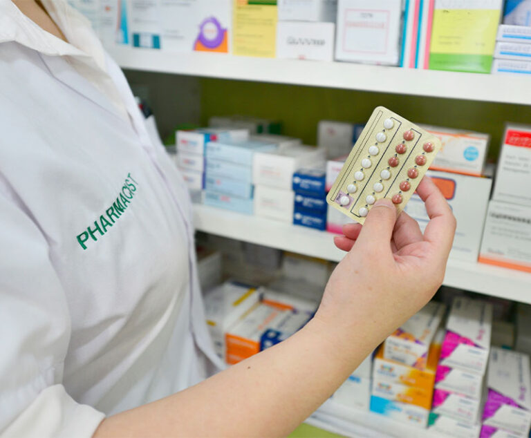 Photo of a pharmacist holding a blister pack of contraceptives
