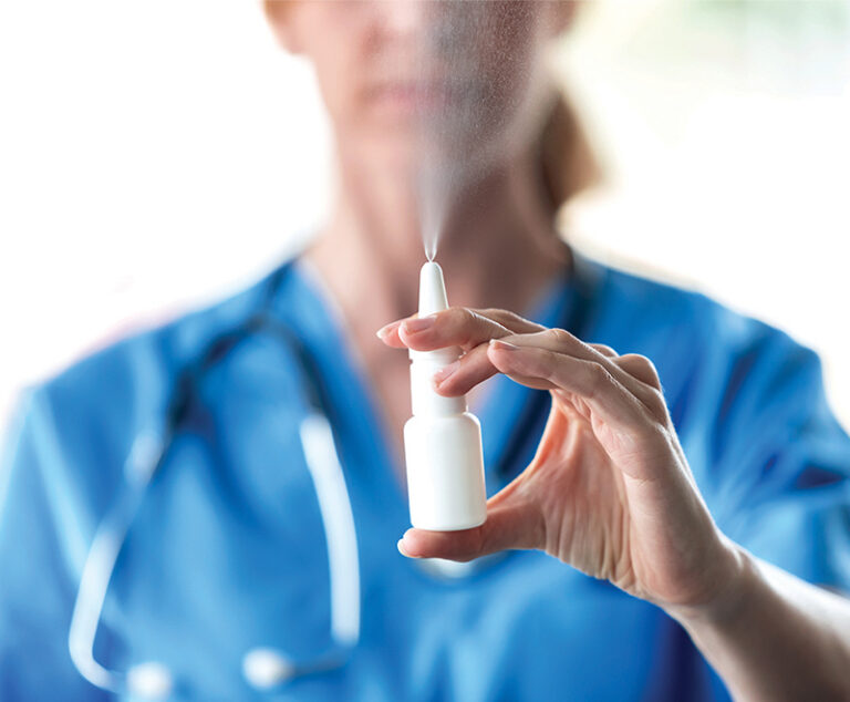 A doctor demonstrating a nasal spray.