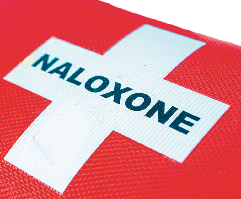 White cross with the word "NALOXONE" across the middle against a red background.