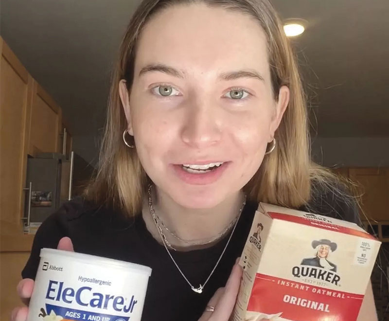 Caroline Cray Quinn holding a box of oatmeal and a container of powdered formula.
