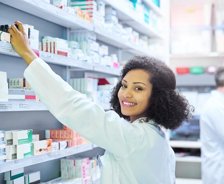 Pharmacist retrieving a medication package from the pharmacy shelf.
