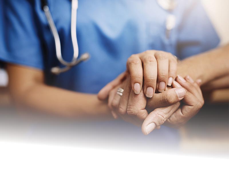 Medical provider holding a patient's hand.